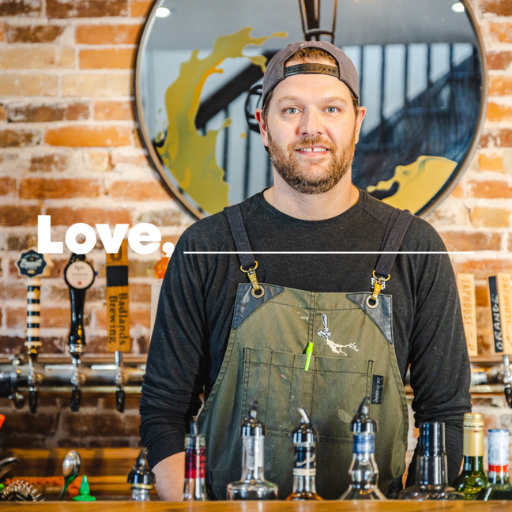 A man standing behind a bar smiling